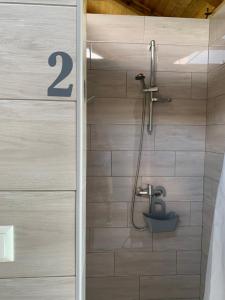 a bathroom with a shower with a number on the wall at Kuća za odmor KRNJAIĆ in Bosanski Novi