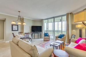 a living room with a couch and a dining room at Perdido Key Condo with Views and Golf Club Access! in Pensacola