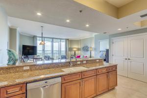 a kitchen with a sink and a living room at Perdido Key Condo with Views and Golf Club Access! in Pensacola