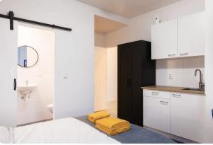 uma cozinha com armários brancos e toalhas amarelas numa cama em Tilburg City, New Rooms And A Kitchen em Tilburg