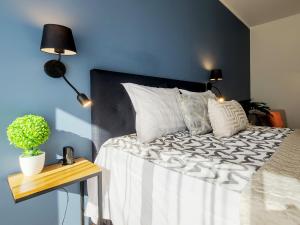 een slaapkamer met een bed met een blauwe muur bij Rotermann City Apartments Roseni in Tallinn