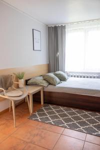 1 dormitorio con cama, ventana y silla en SunRise Mielno, en Mielno