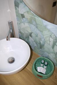 y baño con lavabo blanco y tazón verde. en IL CORTILE DELLE ZAGARE, en Pollica