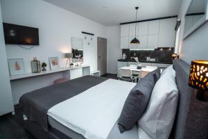 Studioapartment Black & White في فيليكا غوريكا: غرفة نوم بسرير وطاولة ومطبخ