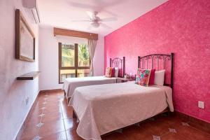 1 dormitorio con 2 camas y pared de color rosa en Great 2BR Master Suite at the Best Boutique Hotel, en Sayulita