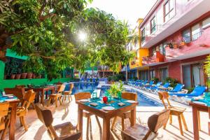un patio del hotel con mesas y sillas y una piscina en Great 2BR Master Suite at the Best Boutique Hotel, en Sayulita 16 fotos más