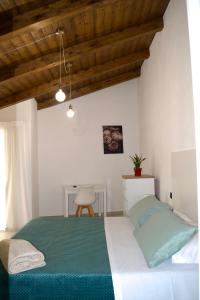 Un dormitorio con una cama verde y una silla en IL CORTILE DELLE ZAGARE, en Pollica