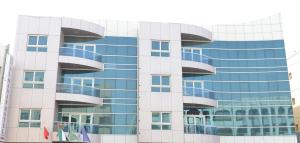 um edifício de vidro alto com janelas azuis em Al Manar Hotel Apartments em Dubai