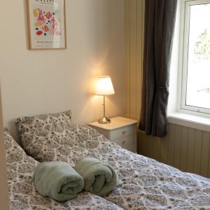 a bedroom with a bed with towels on it at Sentralt og romslig i Kristiansand sentrum in Kristiansand