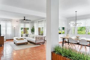 Sala de estar y comedor con sofá y mesa en Daria Beachfront community steps 2 pool- Generator, en Sabana