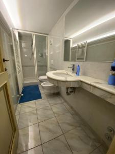 a bathroom with a sink and a toilet and a shower at Puccini's Home, elegant apartment in Piazza Puccini in Lucca