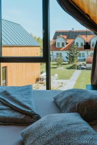 a bedroom with a view of a house through a window at Villa Baltica in Niechorze