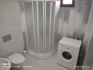 a white bathroom with a washing machine and a toilet at Espinaz Apart Otel in Bostaniçi