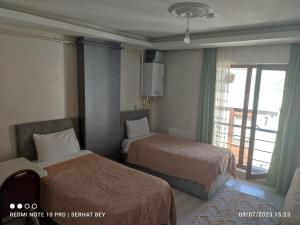 Habitación de hotel con 2 camas y ventana en Espinaz Apart Otel, en Bostaniçi