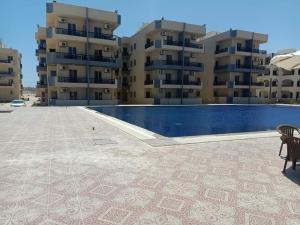 a pool in front of two apartment buildings at شاليه سويت بلو باي مطروح chalet suite blue bay matrouh in Marsa Matruh