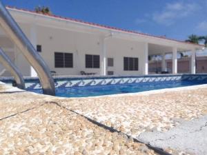 a swimming pool with rocks next to a building at Casa Nahomy in Chichiriviche