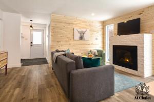 - un salon avec un canapé et une cheminée dans l'établissement Le Loonix- Chalet familiale avec Spa, à Petite-Rivière-Saint-François