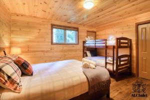 1 dormitorio con 2 camas en una cabaña de madera en Domaine du Hameau en Petite-Rivière-Saint-François