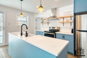 a kitchen with blue cabinets and a white counter top at Le Loonix- Chalet familiale avec Spa in Petite-Rivière-Saint-François +9 photos