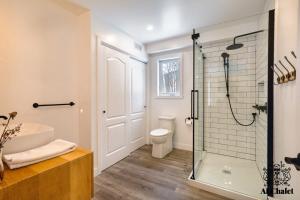 La salle de bains est pourvue d'une douche, d'une baignoire et de toilettes. dans l'établissement Le Loonix- Chalet familiale avec Spa, à Petite-Rivière-Saint-François