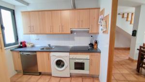 a kitchen with a sink and a washing machine at CASA LA VILLA in Villamartín de Don Sancho