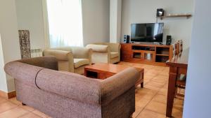 ein Wohnzimmer mit einem Sofa und einem TV in der Unterkunft CASA LA VILLA in Villamartín de Don Sancho