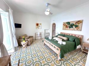 a bedroom with a green bed and a couch at Casalbivio Positano in Positano