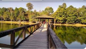 un puente de madera sobre un lago con cenador en Apart Aconchego Mobiliado até 4 pessoas Centro, en Sinop