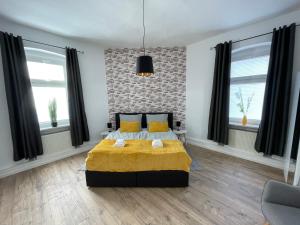 um quarto com uma cama e duas janelas em Modernes, großes City Appartement 95 qm em Meuselwitz