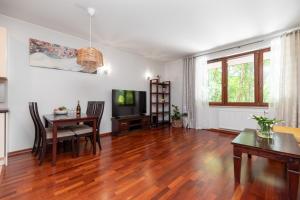 ein Wohnzimmer mit einem Esstisch und einem TV in der Unterkunft Apartament Sopot Haffnera in Sopot