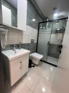 a bathroom with a sink and a shower and a toilet at Feycem Suites&Hotel in Istanbul