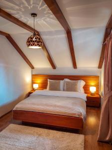 a bedroom with a large bed with two lamps and a rug at or'o apartments in Žabljak