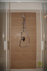 een douche met een douchekop in de badkamer bij Villa Tra i Pini - Green & Relax in Castellana Grotte