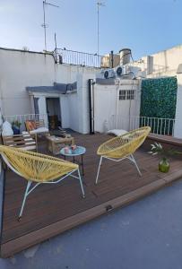 Un patio con dos sillas y una mesa en una terraza. en Fantástico piso nuevo, Mentidero, en Cádiz