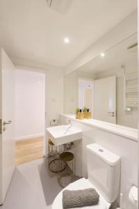 een witte badkamer met een toilet en een wastafel bij Lisbon Charm with Patio in Lissabon