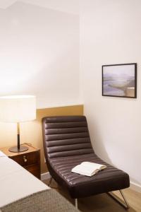 een leren stoel in een hotelkamer met een lamp bij Lisbon Charm with Patio in Lissabon