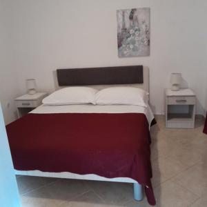 1 dormitorio con 1 cama grande y 2 mesitas de noche en Apartments Viganj, en Viganj
