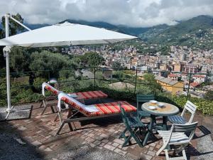 a patio with a table and chairs and an umbrella at Sunrise in Rapallo