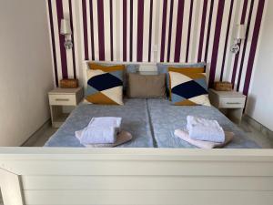 uma cama grande com almofadas e toalhas em Apartment Lena em Vodice
