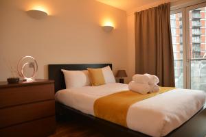 un dormitorio con una cama con un animal de peluche en Canada Water 2Bedroom Apartment en Londres