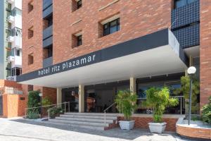 馬塞約的住宿－Ritz Plazamar Hotel，带有读物与药房相遇的标志的建筑物