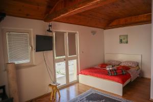 チリピにあるGuest House Godimentoのベッドルーム1室(赤いベッド1台、窓付)