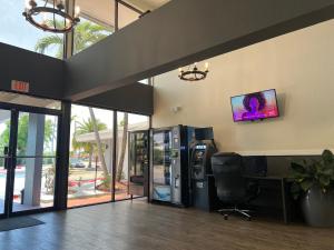 una oficina con escritorio y TV en la pared en Garden Inn Homestead/Everglades/Gateway to Keys en Homestead