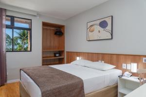1 dormitorio con 1 cama y escritorio con teléfono en Ritz Plazamar Hotel, en Maceió