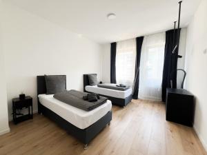 a bedroom with two beds and a couch at Cityapartments Düsseldorf - Stadtmitte in Düsseldorf