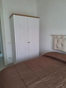 ein Schlafzimmer mit einem Bett und einem weißen Schrank in der Unterkunft la casa del muratore in Trapani