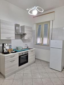 eine Küche mit weißen Geräten und einem weißen Kühlschrank in der Unterkunft la casa del muratore in Trapani