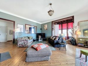 ein Wohnzimmer mit einem Sofa und einem Stuhl in der Unterkunft Appartement exception avec vue sur mer imprenable in Lion-sur-Mer