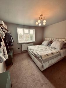 a bedroom with a large bed and a window at Chic Family Home Near Parks & Leicester Uni in Leicester