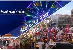 a crowd of people at a carnival with a ferris wheel at Ramon - Y - Cajal in Fuengirola